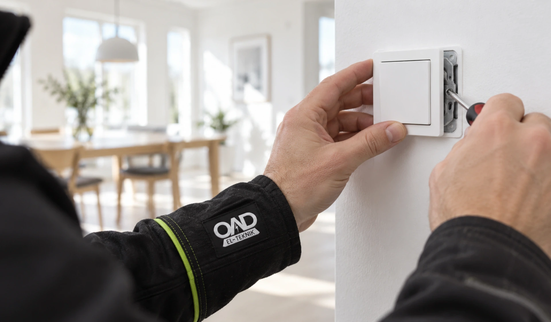 Elektriker installerer en stikkontakt i et moderne hjem.